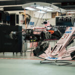 A disassembled race car in a racing garage.