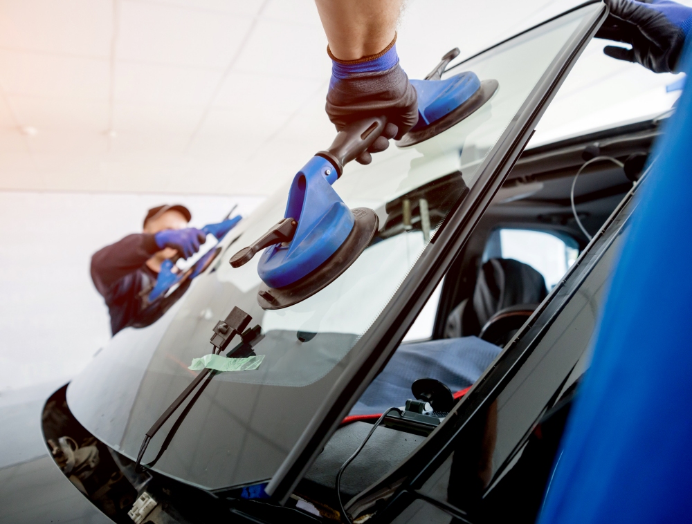 People working on a windshield.