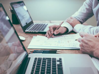 Business people discussing costs for the Comparing the Value of Annual Maintenance for On-Premises ERP vs. Cloud Updates blog from PC Bennett.