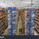 Rows of stacked boxes on shelves in a warehouse.
