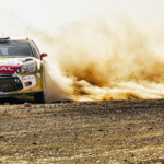 Race car driving on a dirt road.