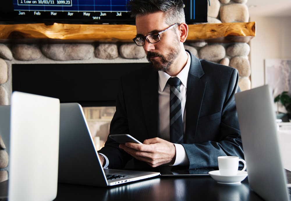 Man working on phone and laptop.