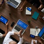 Group of business people working on laptops at a conference table during a business meeting.