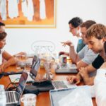 Group of business people working on laptops on a conference room table.