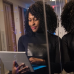 Woman standing while working on laptop.