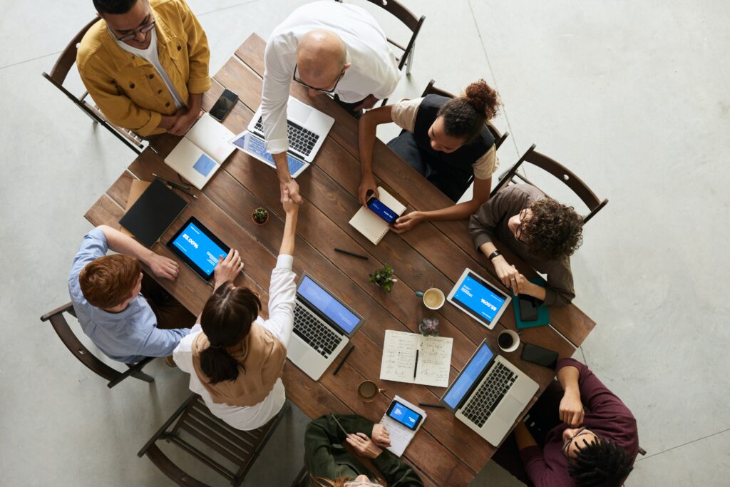 Eight team members having a meeting around a table.