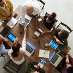 Eight team members having a meeting around a table.