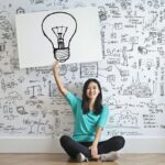 Girl with lightbulb sign.