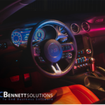 Car steering wheel with PC Bennet Solutions logo at the botton.