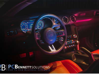 Car steering wheel with PC Bennet Solutions logo at the botton.
