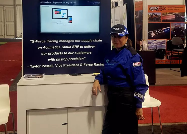 Woman standing next to a Acumatica Cloud ERP display.