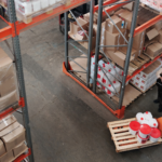 Overhead image of two workers in a warehouse amongst inventory, one of the industries ERP Solutions optimizes.