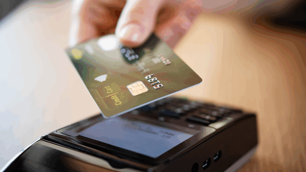 Image of a credit card being read by a scanner with Nuvei processing the payment.